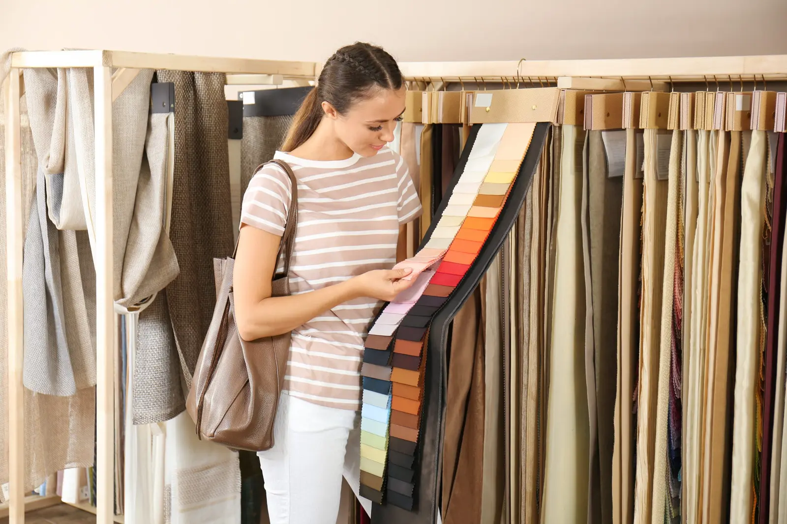 Clienta comparando muestras de tejido en una asesoría de diseño de cortinas