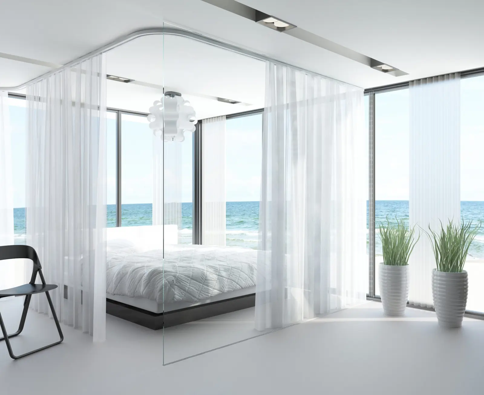Visillos de riel de techo alrededor de la cama en un dormitorio con vista al mar